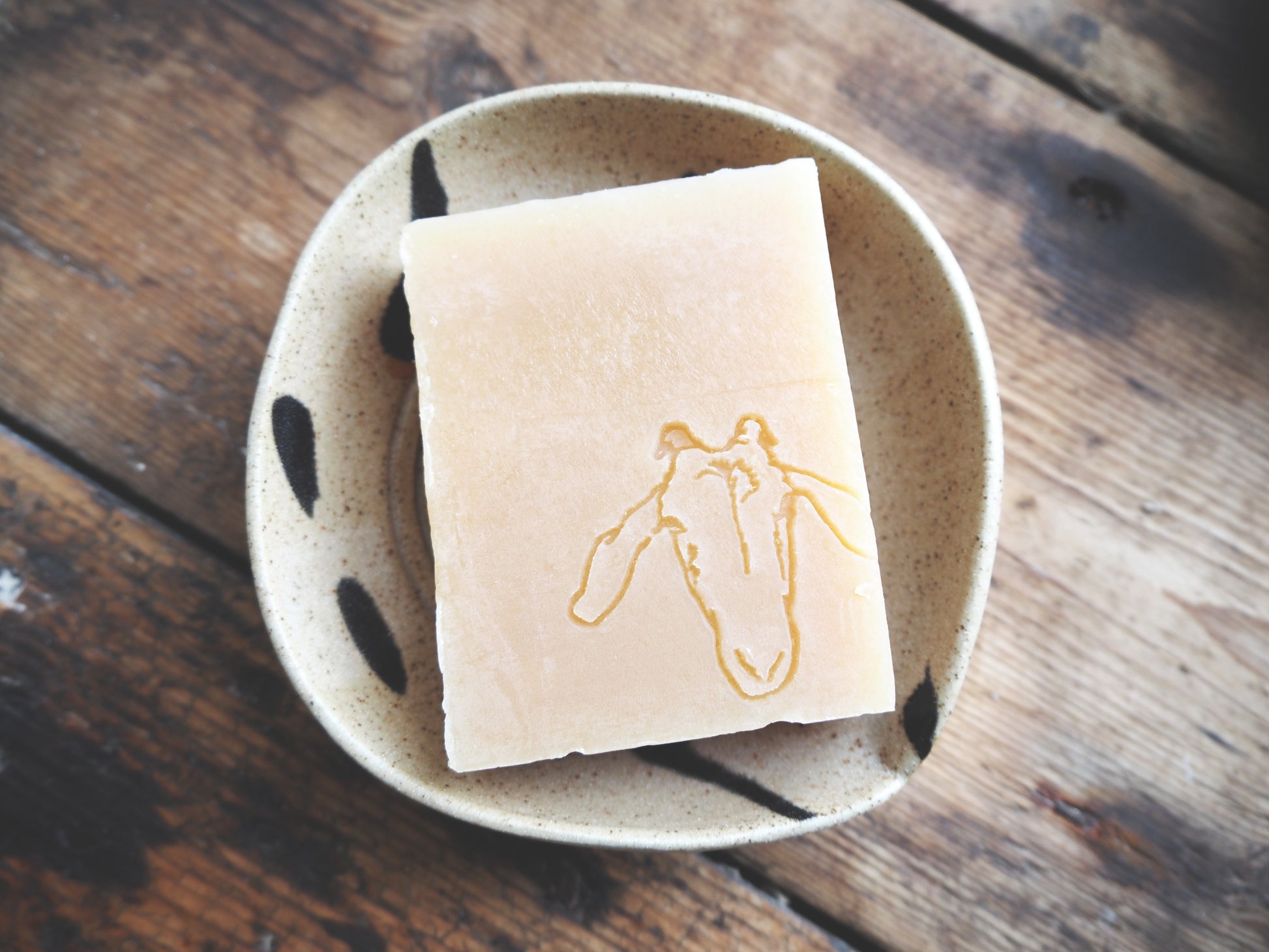 Goat milk soap for sensitive skin displayed on a natural dish, showcasing its gentle and unscented quality.
