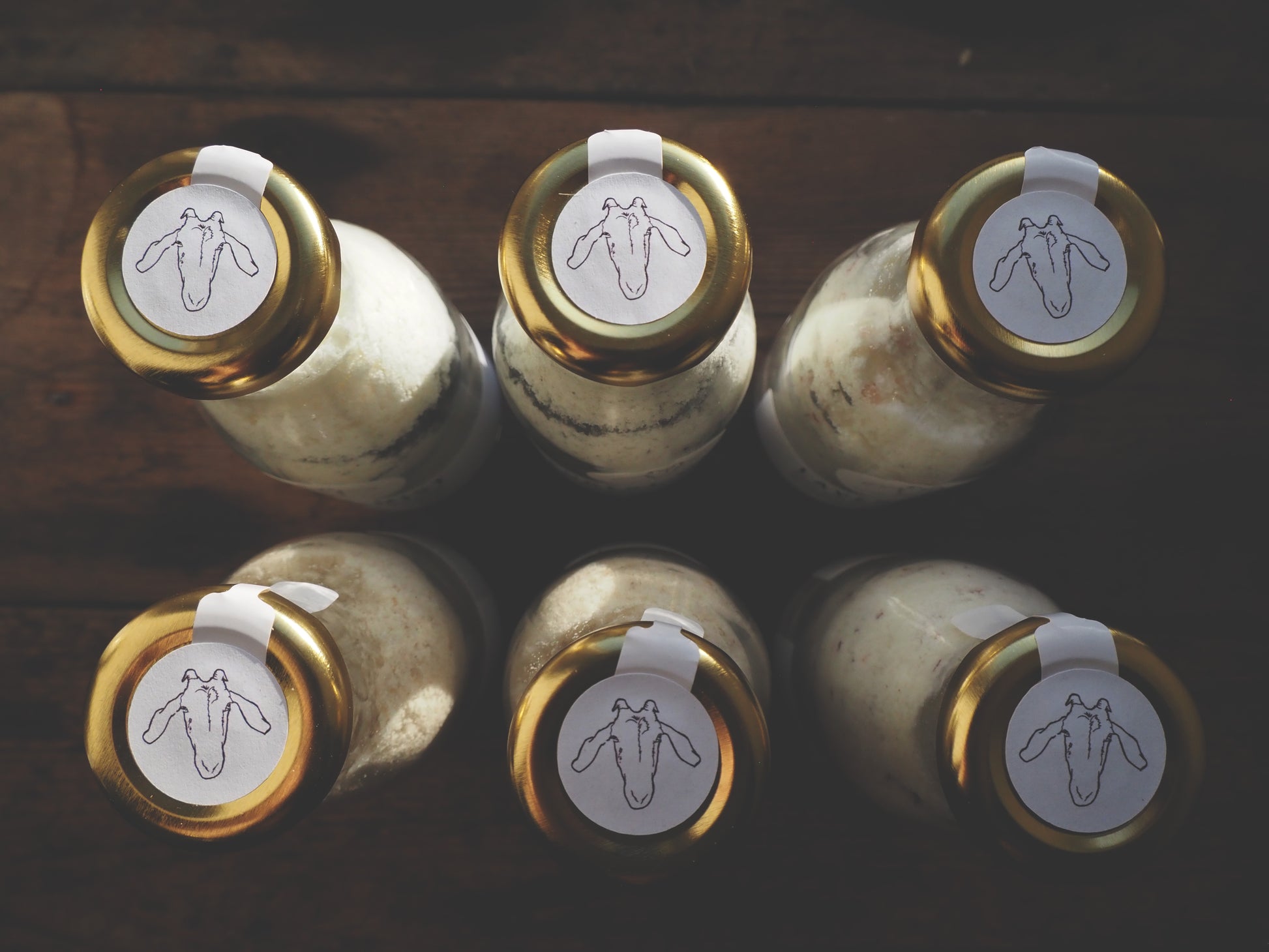 Goat Milk Bath Salts bottles with gold caps and logos on top, arranged for a soothing bath experience.