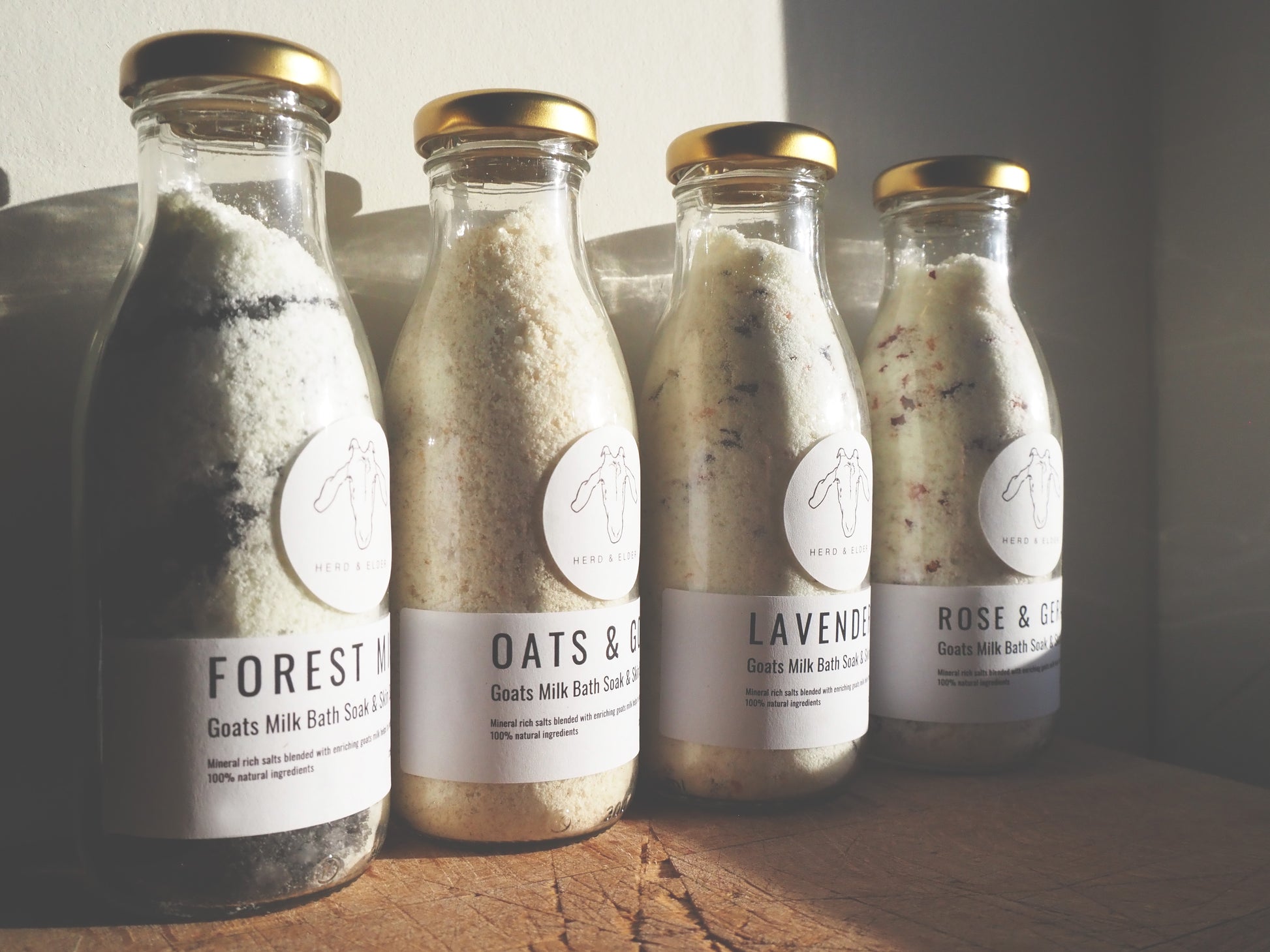 Goat Milk Bath Salts in glass bottles including Forest, Oats & Honey, Lavender, and Rose & Sea Salt scents.