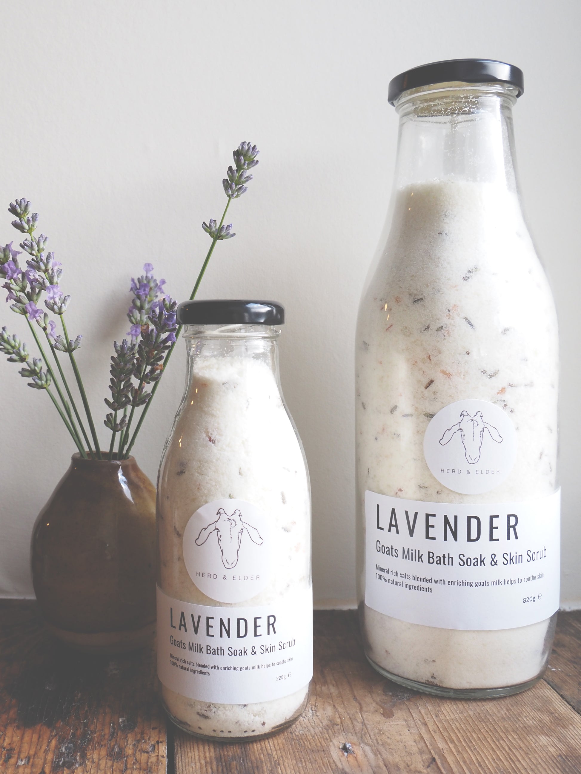 Luxury Goat Milk Bath Salts – Lavender & Botanical Soak with Essential Oils in glass bottles on wooden table.