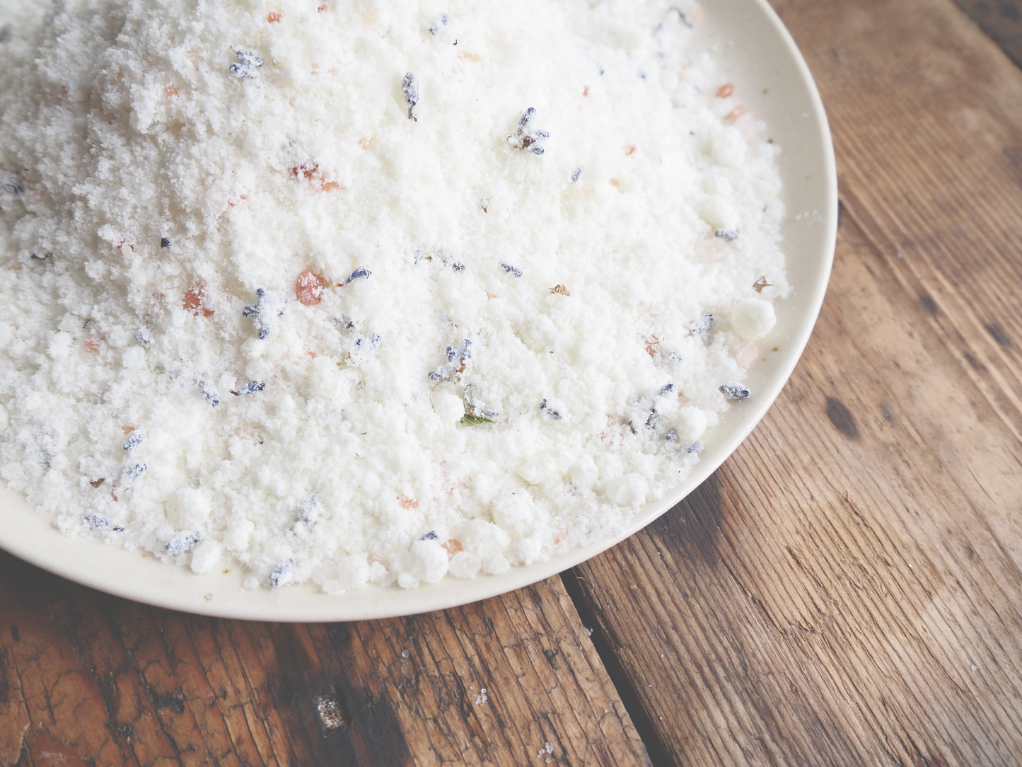 Luxury Goat Milk Bath Salts – Lavender & Botanical Soak with Essential Oils in a bowl on wooden surface.