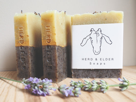 Three bars of goats milk soap with lavender, handcrafted by Herd & Elder, showcasing natural ingredients and rustic design.