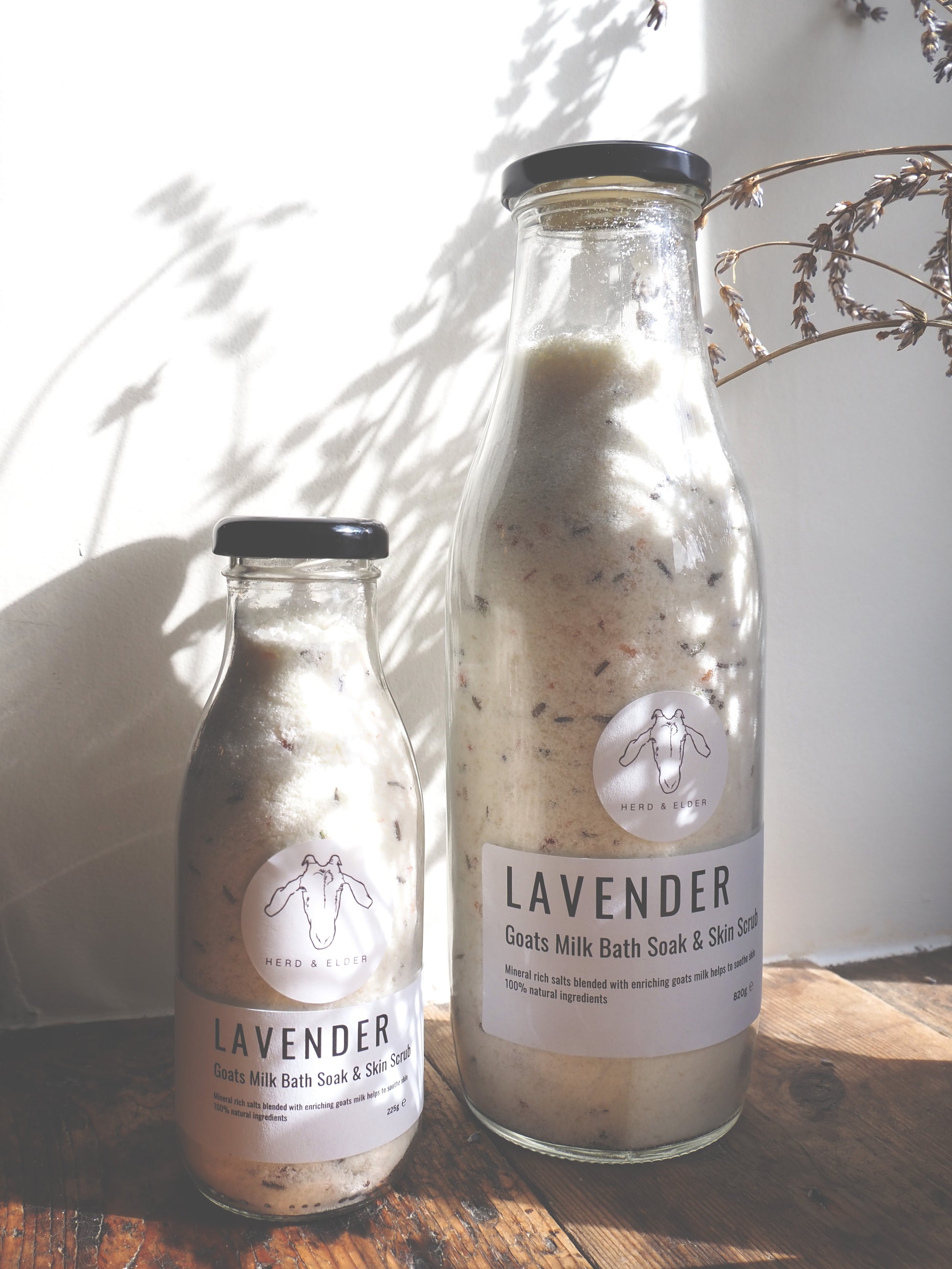 Luxury Goat Milk Bath Salts – Lavender & Botanical Soak with Essential Oils in glass bottles on wooden surface.