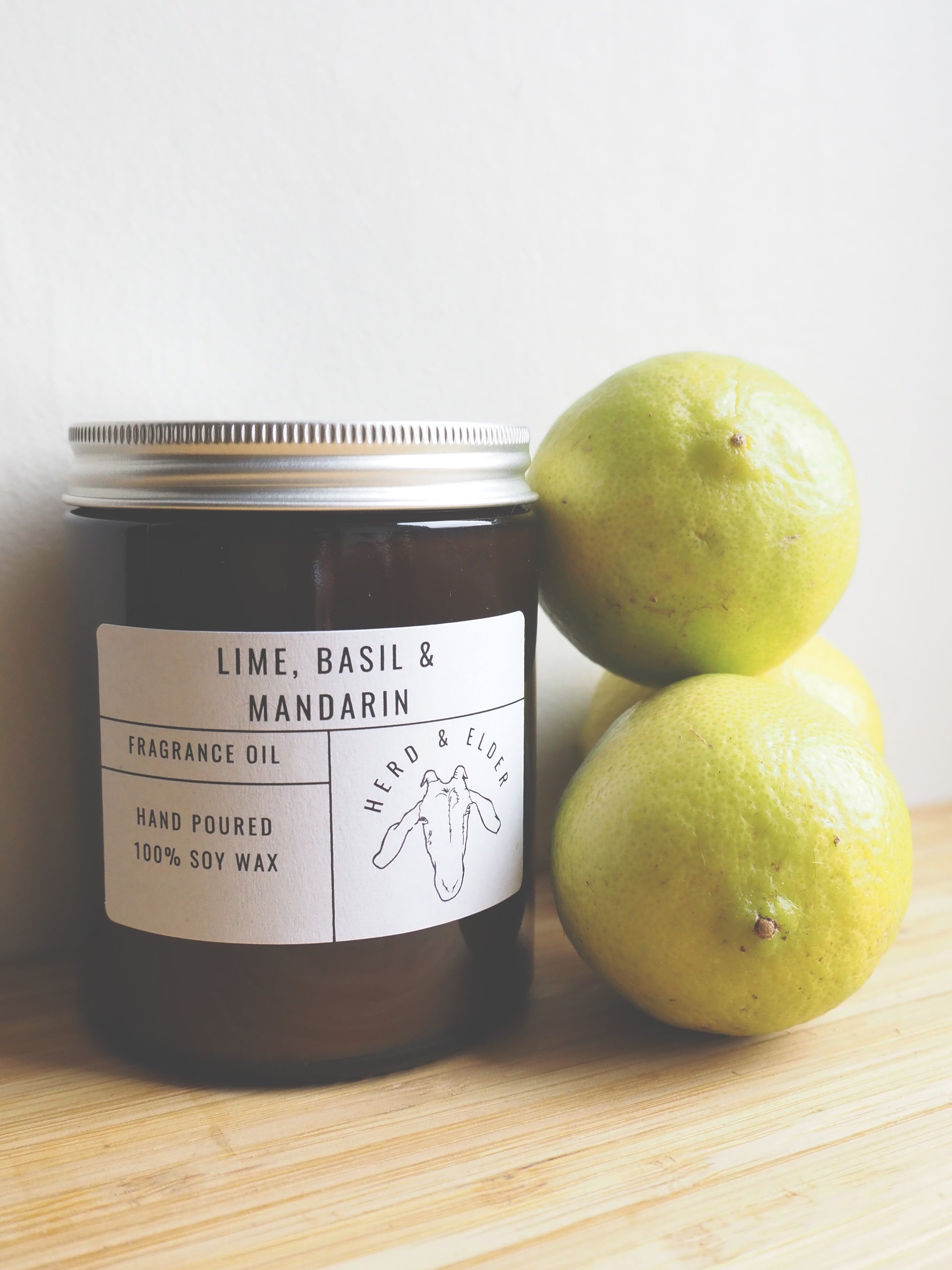 Lime Basil and Mandarin Soy Wax Candle by Herd & Elder with fresh limes for a vibrant scent.